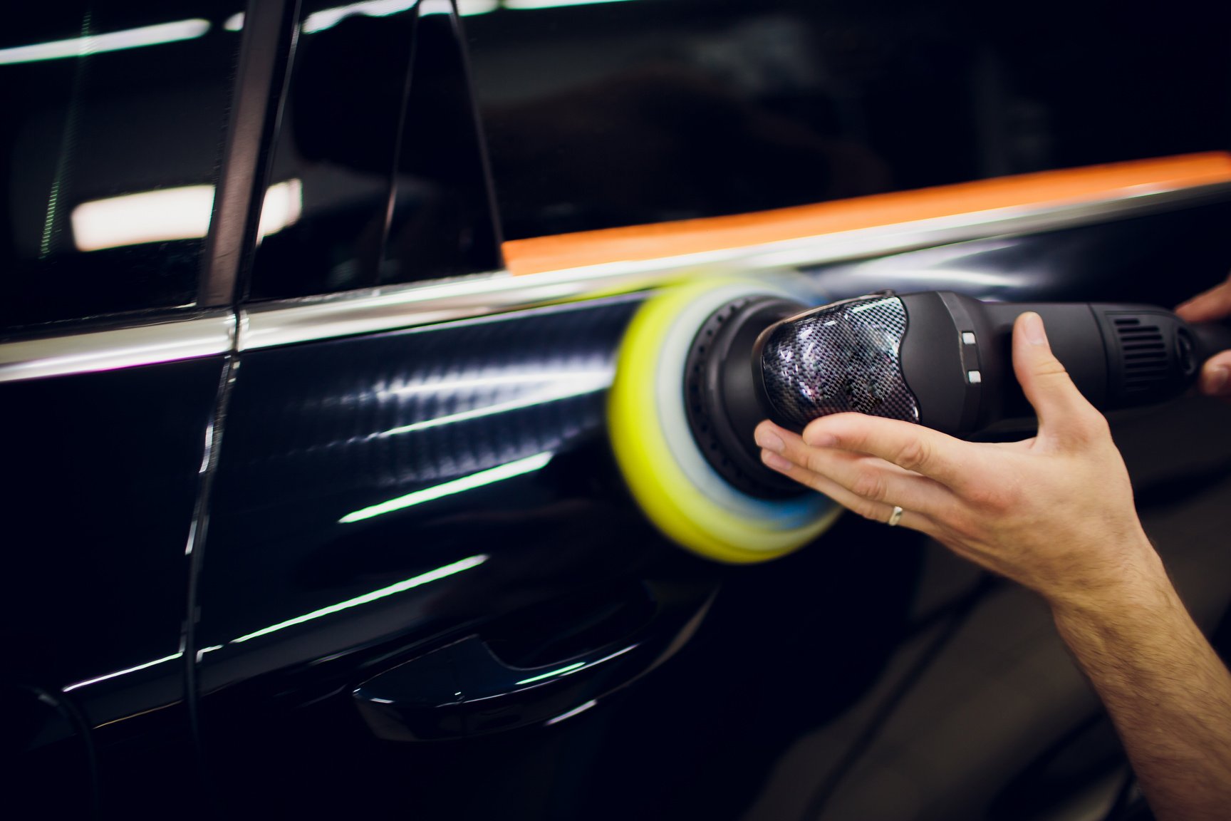 Polished black car polishing machine polished finishing. Car detailing. Selective focus.